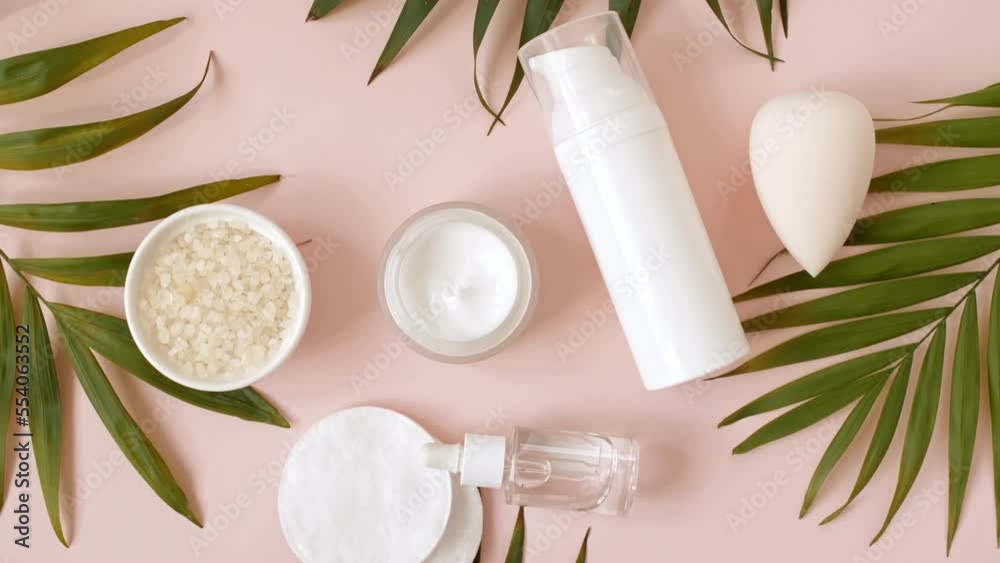 Eco friendly products on pink background with palm leaves. Bottle with pipette with gel, collagen serum, essential oil, salt, soap, sponge. Natural organic skin care eco-cosmetics. flat lay. 4k Eco friendly products on pink background with palm leaves. Bottle with pipette with gel, collagen serum, essential oil, salt, soap, sponge. Natural organic skin care eco-cosmetics. flat lay. 4k