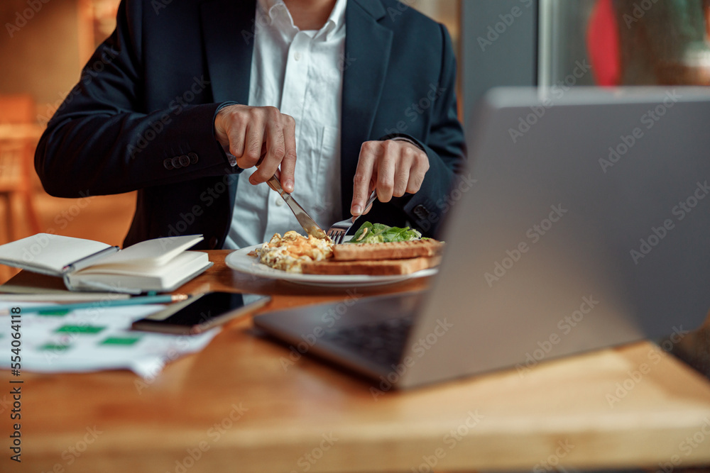 Close up of businessman taking a breakfast before starting working day in cafe Close up of businessman taking a breakfast before starting working day in cafe