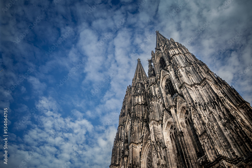 Cologne Cathedral seen from below with blue sky. Cologne Cathedral, or Kolner Dom, is the main landmark of Cologne and a catholic church in Germany...