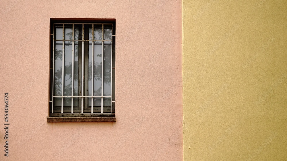 window with grille in colored facade