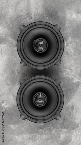 Stylish car audio acoustic round speakers on gray concrete background