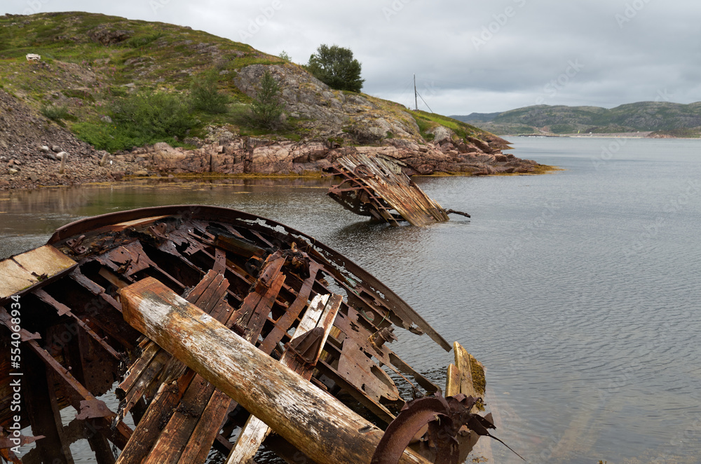 The wreck of an abandoned wrecked ship in the water near the shore The wreck of an abandoned wrecked ship in the water near the shore