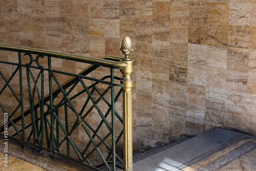 Horizontal view of entrance to a posh old building with descending staircase  terrazzo floor and pretty green and brass metal railing  Santiago  Chile