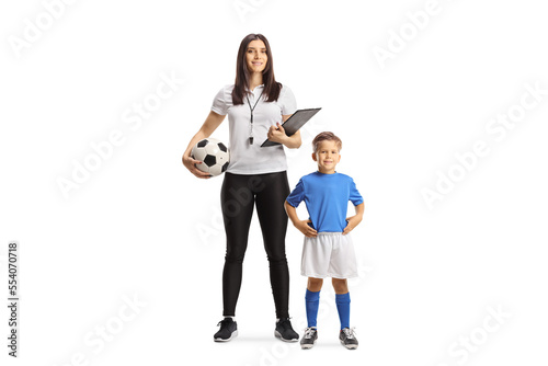 Full length portrait of a female football coach with a whistle holding a clipboard standing with a boy