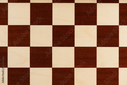 Background from empty wooden chess board, top view.