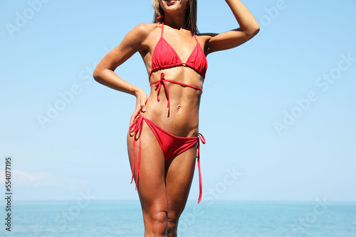 Sexy young woman in stylish bikini on seashore, closeup