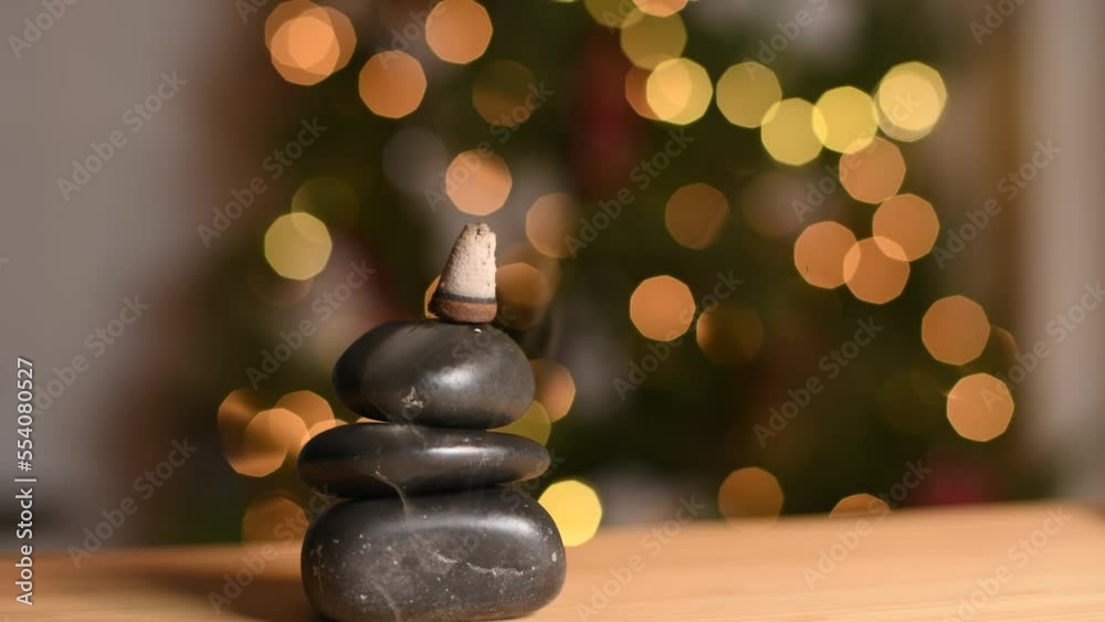 Incense smoke is flowing over zen stones. Heavy backflow smoke fountain of the incense cone Incense smoke is flowing over zen stones. Heavy backflow smoke fountain of the incense cone