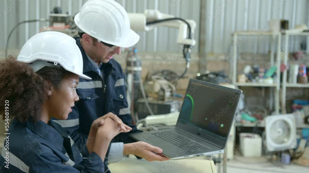 The two engineers check the operation of welding robots. ready to transfer and exchange experiences each other's skills
