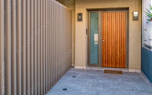 Contemporary house entrance with a natural wooden door  Athens   Greece.
