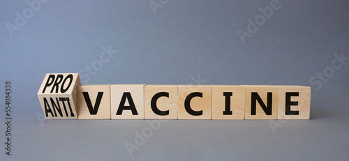 Pro-vaccine vs Anti-vaccine symbol. Turned wooden cubes with words Anti-vaccine vs Pro-vaccine. Beautiful grey background. Medicine concept. Copy space