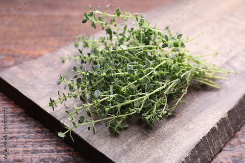 Bunch of aromatic thyme on wooden table, closeup. Fresh herb