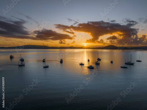 Aerial sunrise waterscape with boats  clouds and reflections