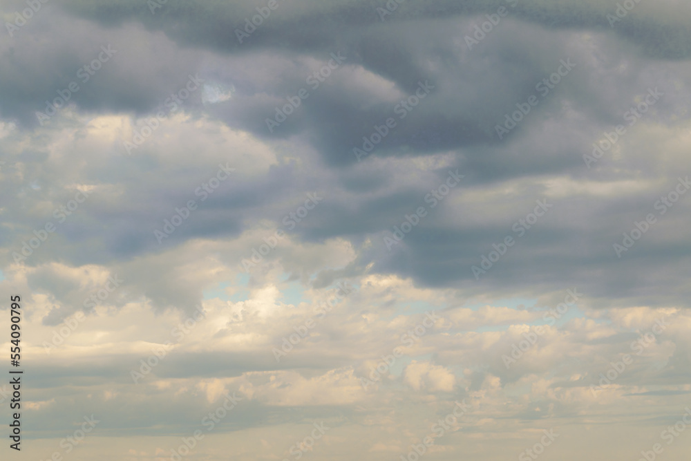 Summer evening sky in the picturesque clouds, lit by the rays of the setting sun.