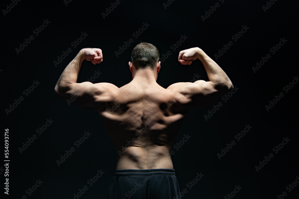 bodybuilder with muscular back isolated on black background. muscular bodybuilder