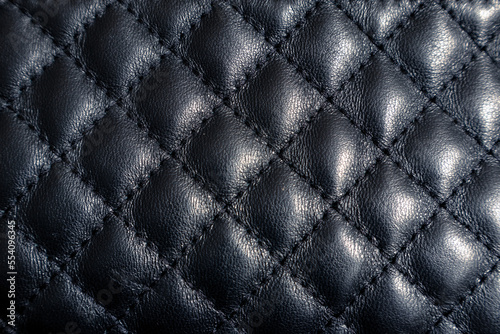 Texture of black leather. Black leather stitched with parallel lines. Rhombus textured leather