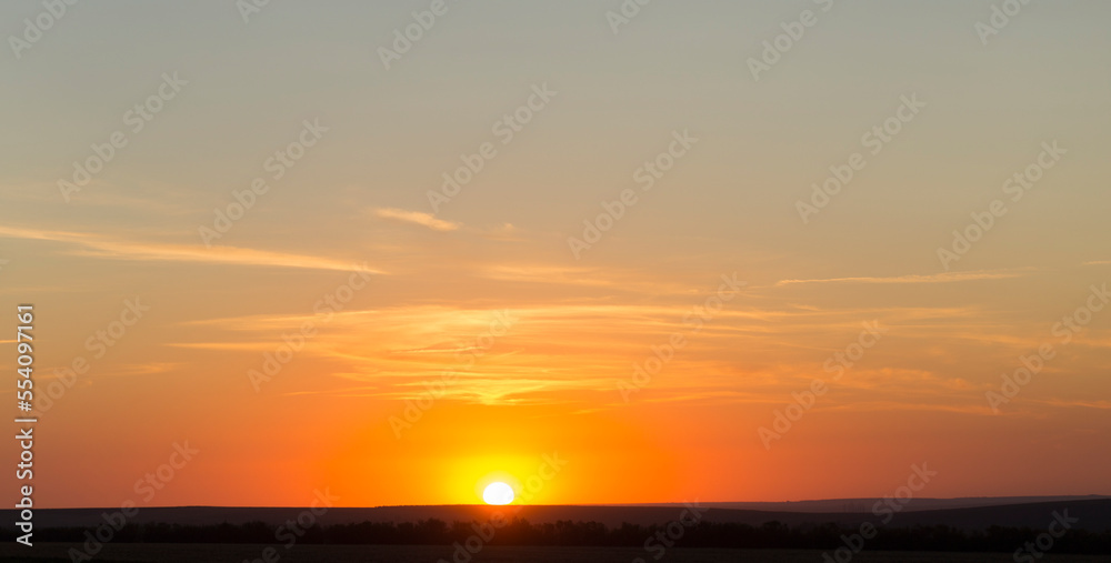 Panorama. Landscape with dawn. The sun rises through light cirrus clouds.