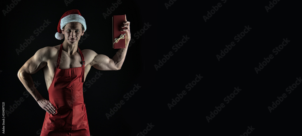 muscular santa with christmas present isolated on black background. christmas banner of muscular man