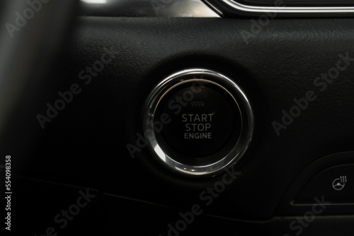 Close up engine car start stop button. Modern car black interior details.