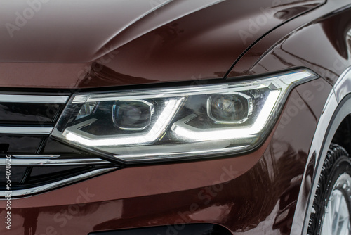 Headlight lamp of new cars. Close up detail on one of the LED headlights modern car. Exterior closeup detail. Closeup headlights of car. © Roman