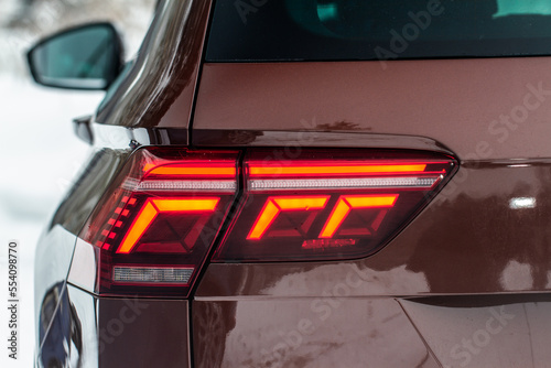 Modern rear light of a car. Brake light and arrow of large suv. Rear light of car close up view. Tail light. © Roman
