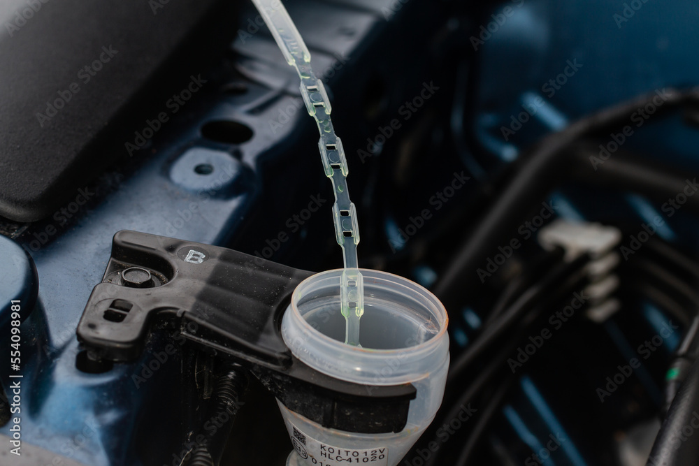 Closeup blue windshield washer fluid reservoir cap. Car engine windshield washer fluid reservoir cap close-up