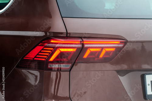 Modern rear light of a car. Brake light and arrow of large suv. Rear light of car close up view. Tail light. © Roman
