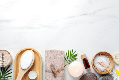 Flat lay composition with different spa products on white marble table. Space for text