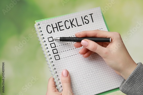 Woman filling Checklist against blurred background, closeup