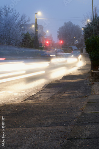 Motion blur lights on cars queuing down a hill on a frosty winter evening