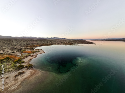 wide angle view from aerial view drone shot of lake mohave in the national recreation area of lake mead in nevada and arizona with the sun setting showing six mile cove and its sand