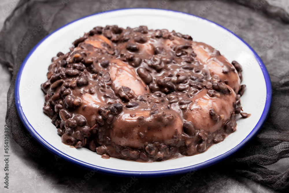 black beans stew with sausages on a white dish black beans stew with sausages on a white dish