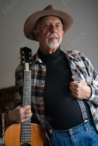 Portrait of senior man with hat and guitar. Blues and country musician
