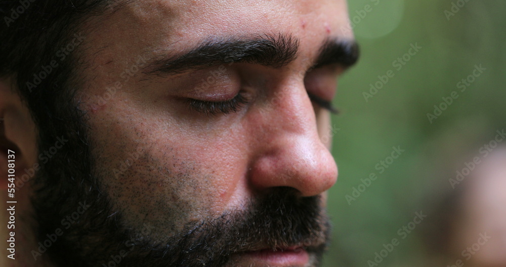 Man meditating outside in nature. Close-up of person face breathing in meditation Man meditating outside in nature. Close-up of person face breathing in meditation