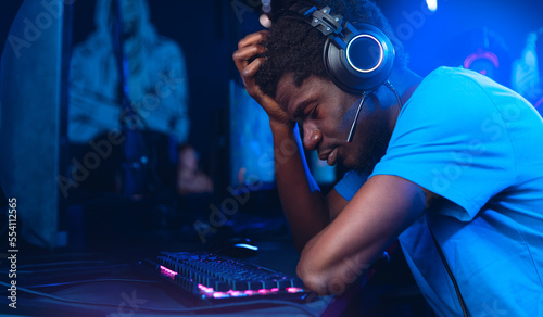 Professional American African gamer upset, tears from losing games of tournaments esport online video, red and blue color background