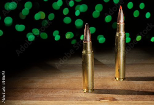 Thirty caliber cartridges with Green Christmas lights behind