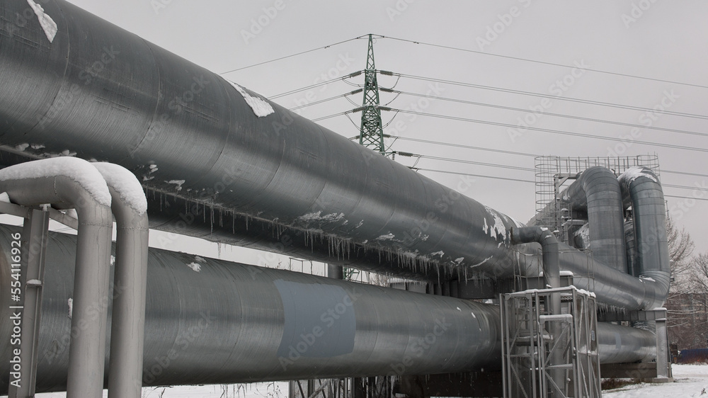 pipeline and power line in the city in winter against the gray sky.