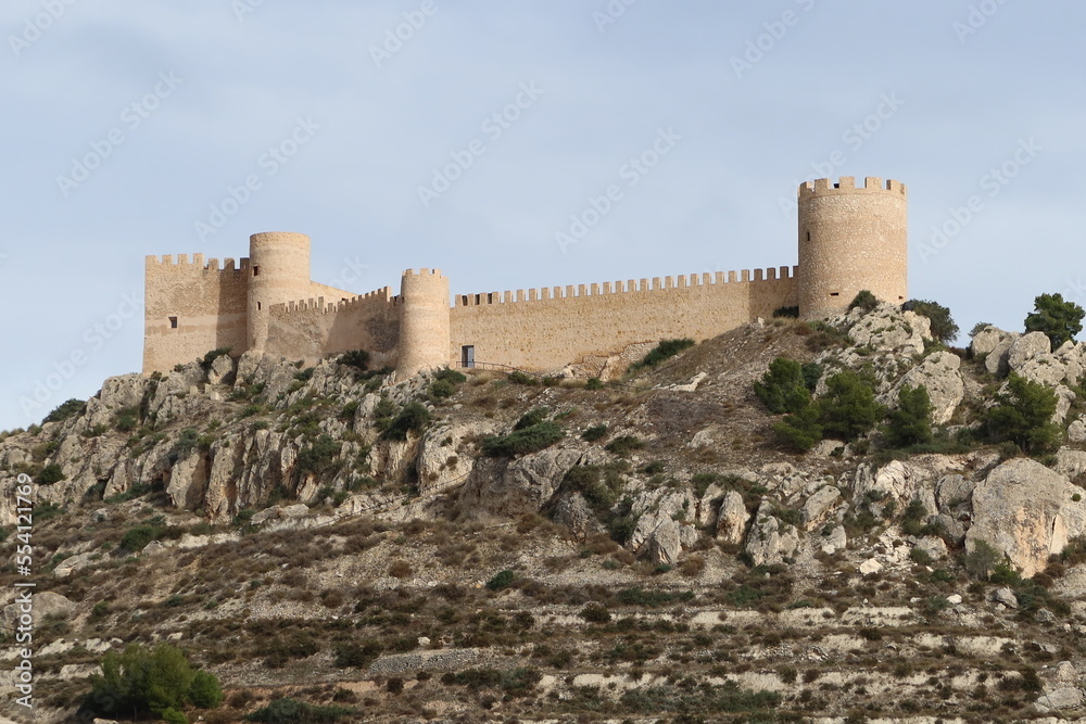 Castalla, Alicante, Spain, December 15. 2022: Towers and fortified walls of the castle of Castalla on the mountain, Alicante. Spain