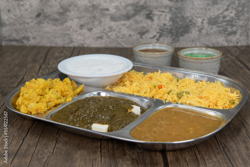 Traditional Indian meal in a partitioned tray with all the vegetarian favorites along with humus dipping sauce