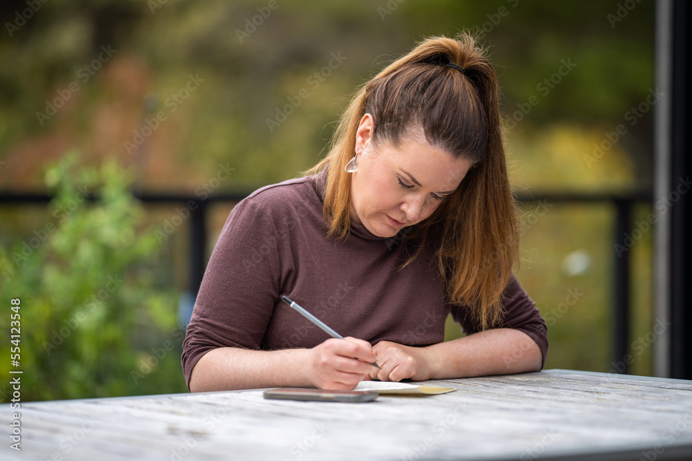 mature university student writing outside studying mature university student writing outside studying