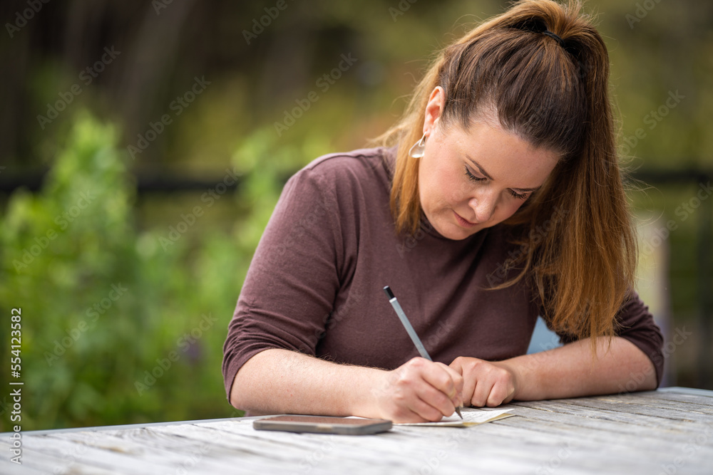 mature university student writing outside studying mature university student writing outside studying