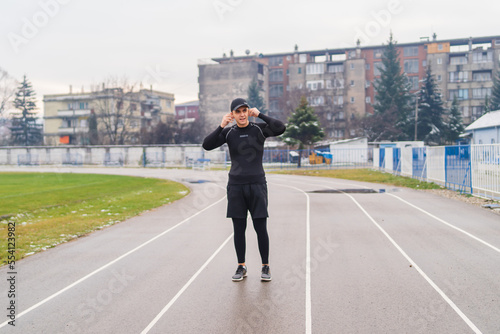 A young man training running stretching jumping a rope on the stadium early in the cold morning  © Dusan