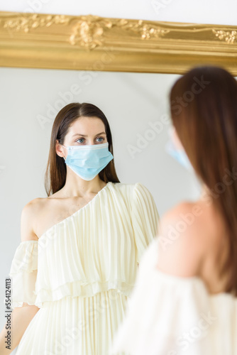 Girl in face mask studying her own reflection