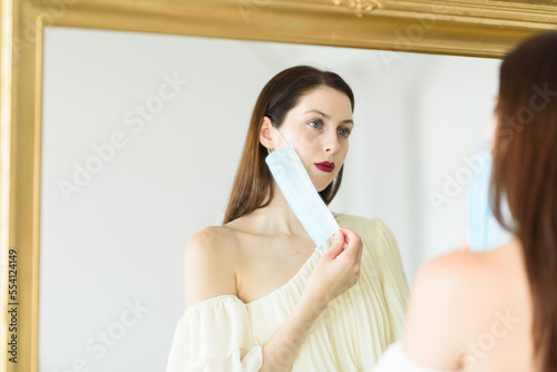 Girl with dark red lipstick holding face mask