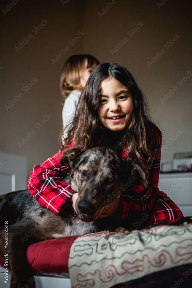 smiling girl in checked pajama holds her grey dog smiling girl in checked pajama holds her grey dog