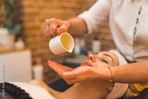 Wallpaper Mural A beautician applying oil for facial skin massage for a woman. High quality photo Torontodigital.ca