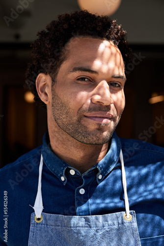 Portrait of male cafe owner with sunlight on face