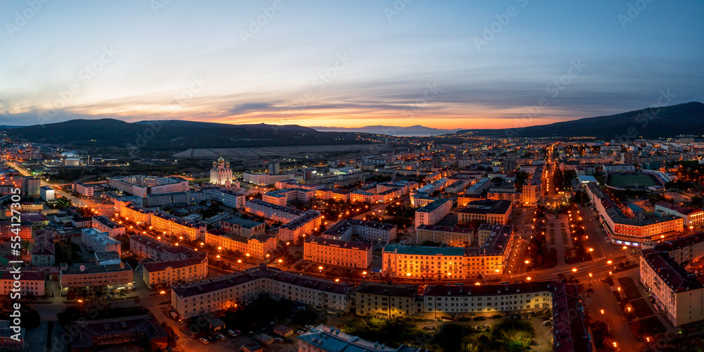 Night panoramic aerial photograph of the city of Magadan. Top view of the streets and buildings. Early morning, dawn. Magadan, Magadan region, Russian Far East.