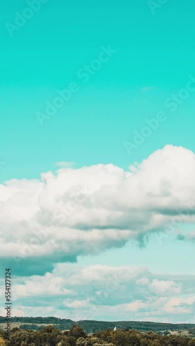 The formation of white clouds in rural hills in retro colors. Vertical video photo