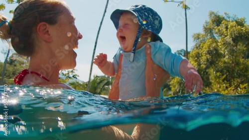 Mother and kid in the pool. Infant boy swims in the warm pool with his mother and enjoys water