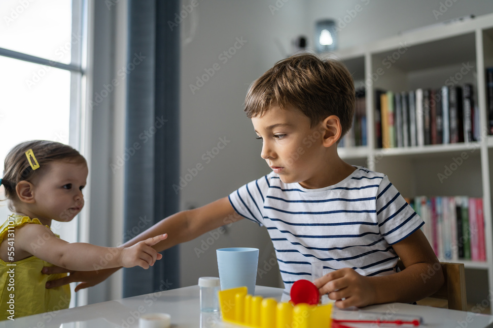One boy trying to stop his little sister to take his toys siblings One boy trying to stop his little sister to take his toys siblings